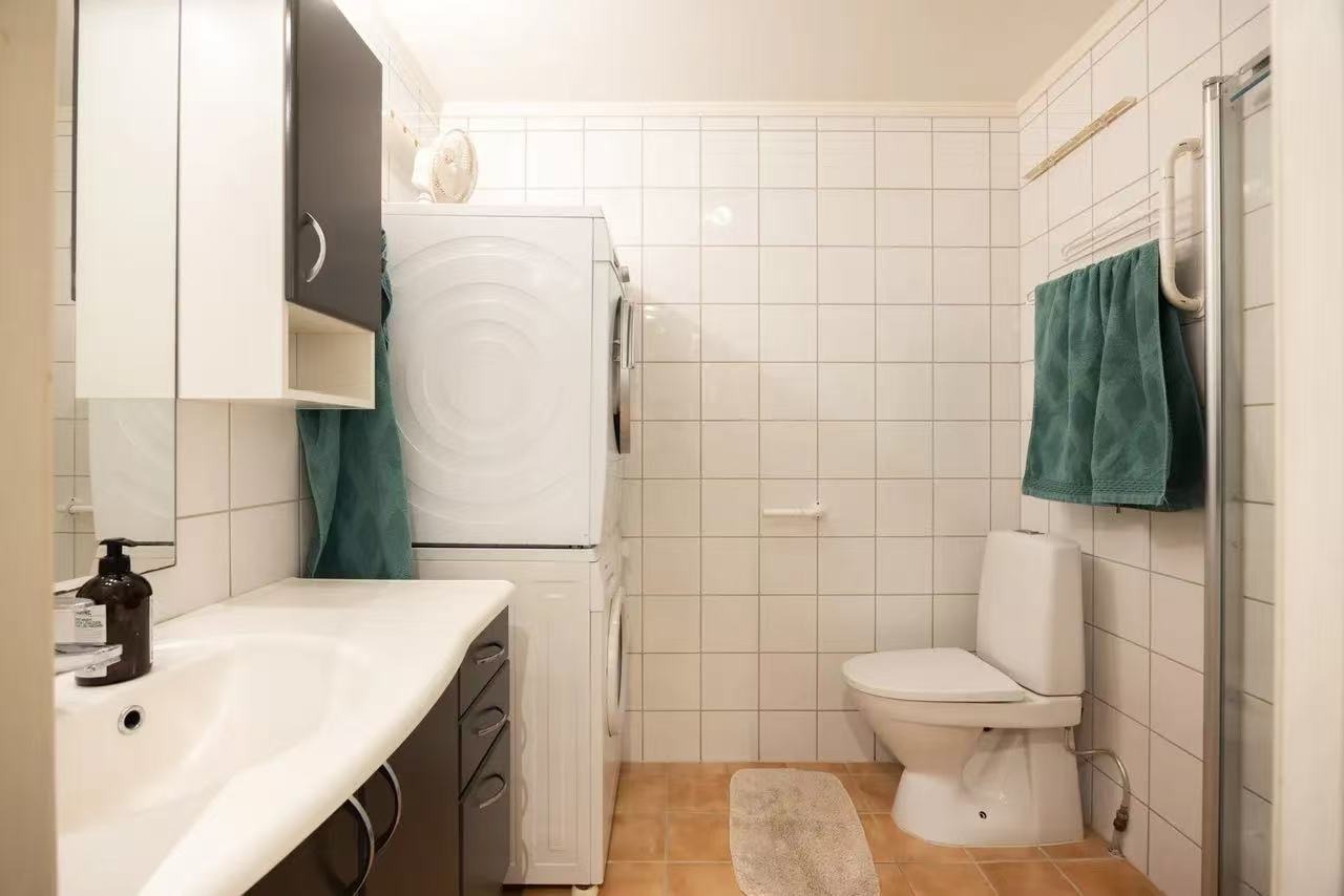 bad med dusj, toilet, vaskemaskin og tørketrommel